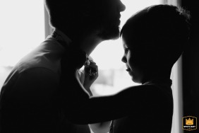 At the couple's home, a heartwarming moment captured as the groom's son helps his father tie his bow tie before the civil ceremony in Chateauroux.